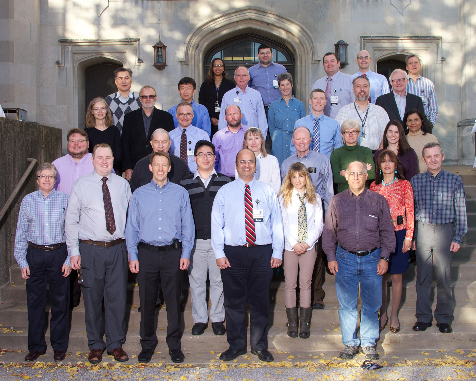 Pathology faculty standing on the stairs outside of the medical research labs