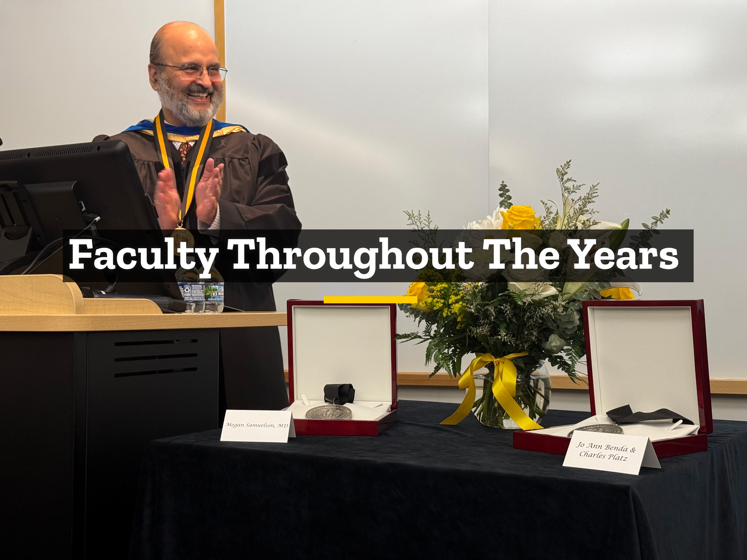 Dr. Karandikar at a podium clapping and smiling, wearing ceremonial robes