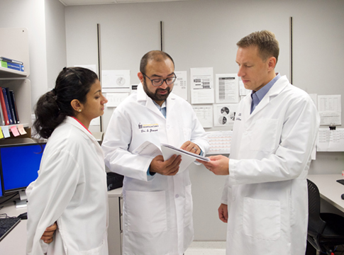 Three doctors looking over documents together