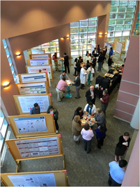 An overhead view of people looking at research posters