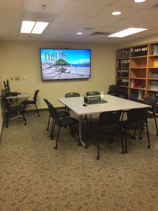 A conference room with a library and large screen