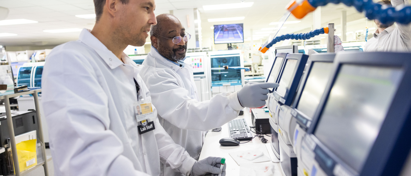 Two people operate a radiometer blood gas analyzer