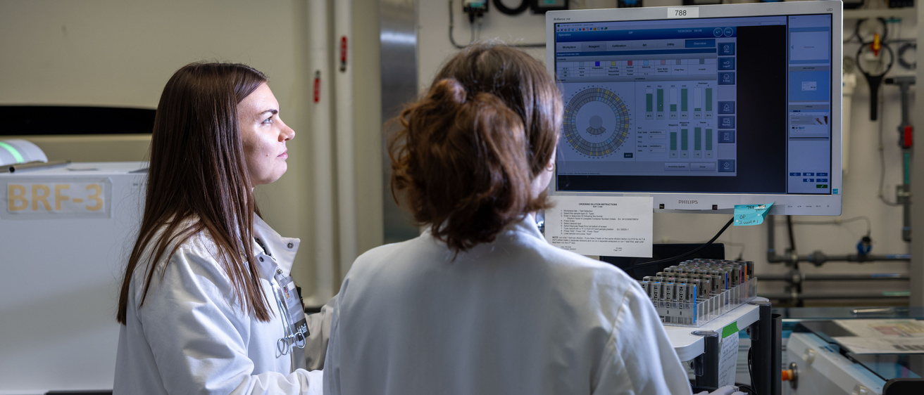 Two people looking at a computer screen in the core labs