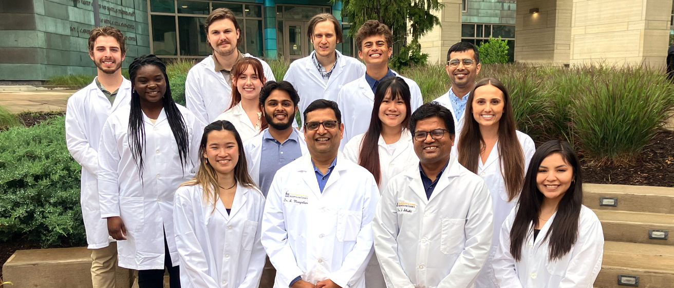 Mangalam lab members smiling, wearing white coats