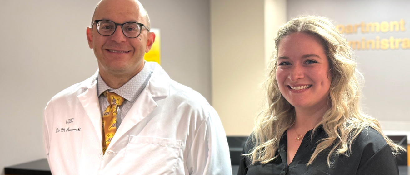 Dr. Krasowski and Alexis smiling in front of the Pathology front desk
