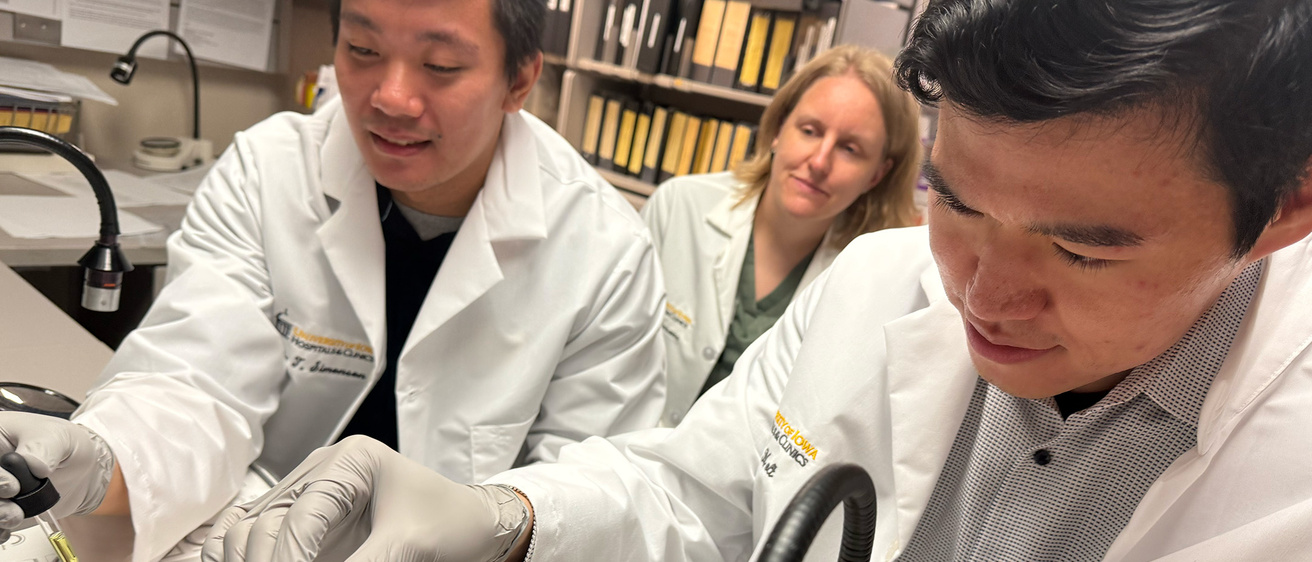 Two med students being taught by a faculty member