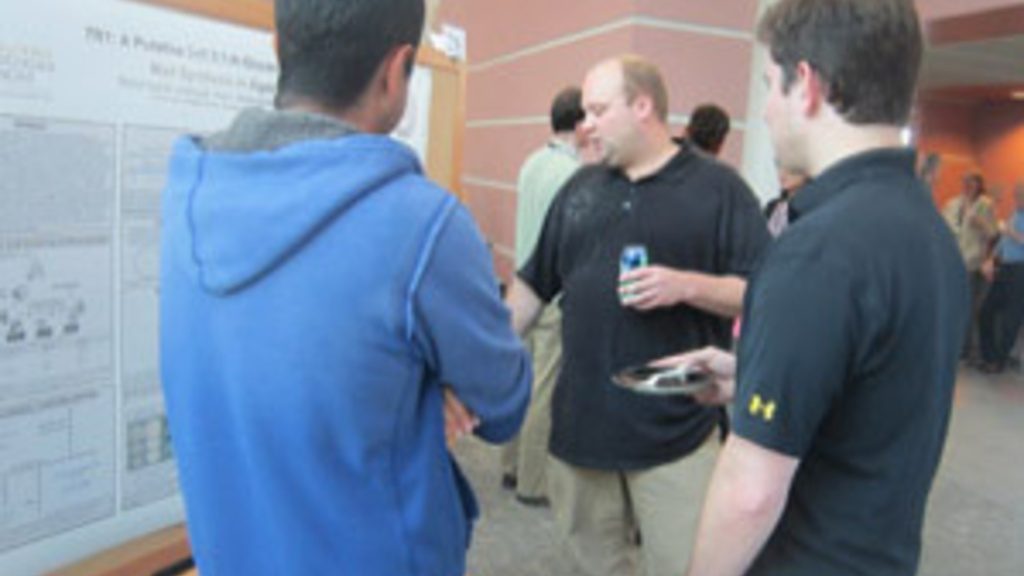 A group of people looking at a research poster