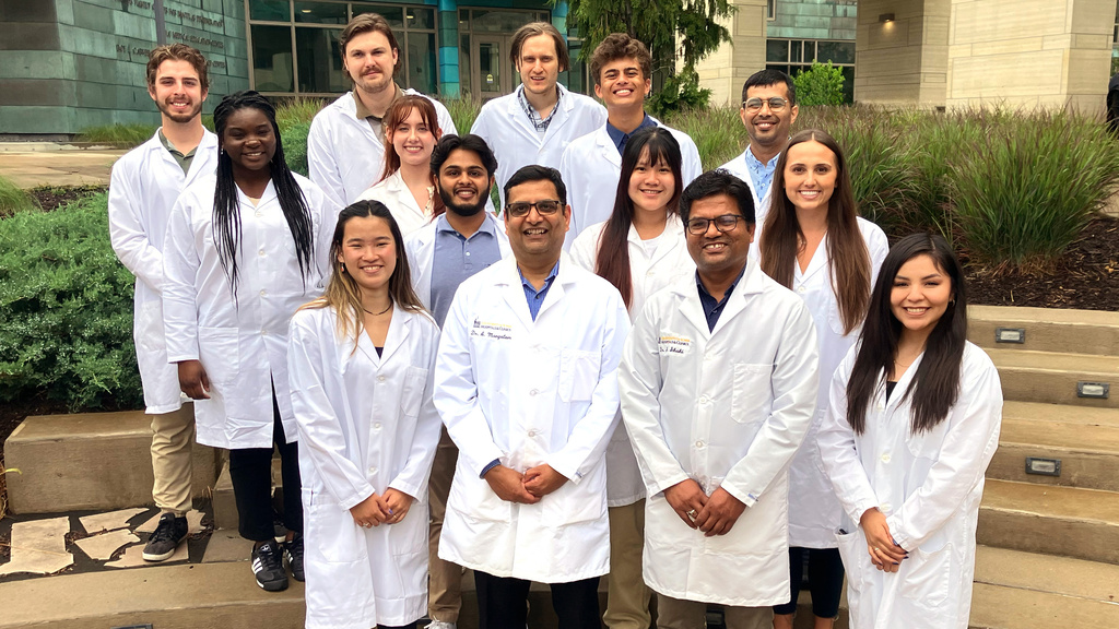 Mangalam lab members smiling, wearing white coats