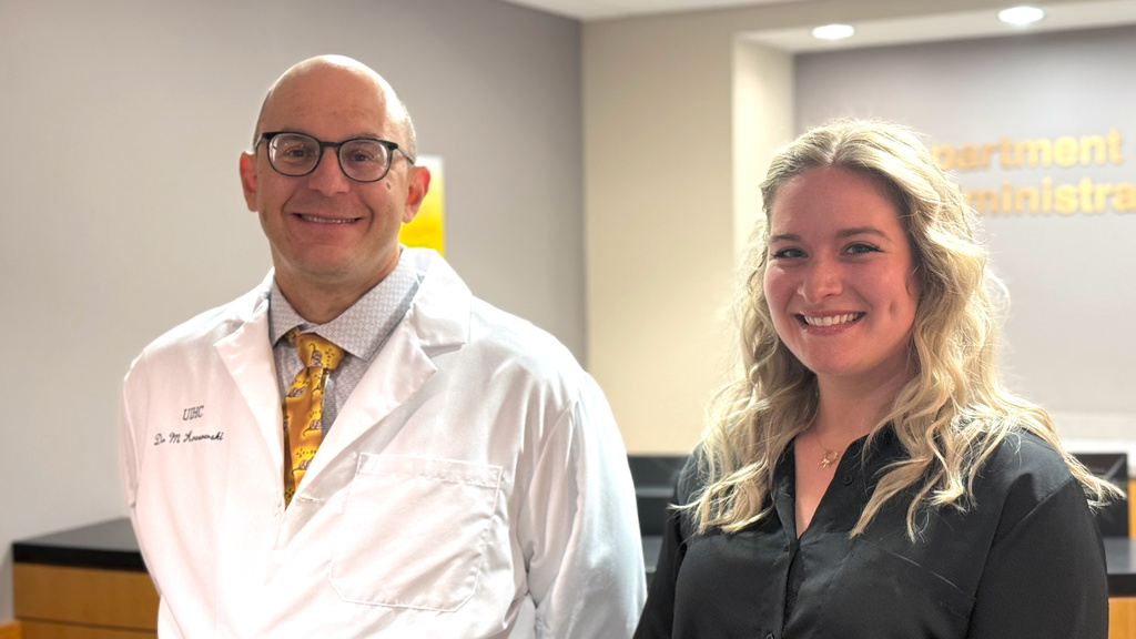Dr. Krasowski and Alexis smiling in front of the Pathology front desk