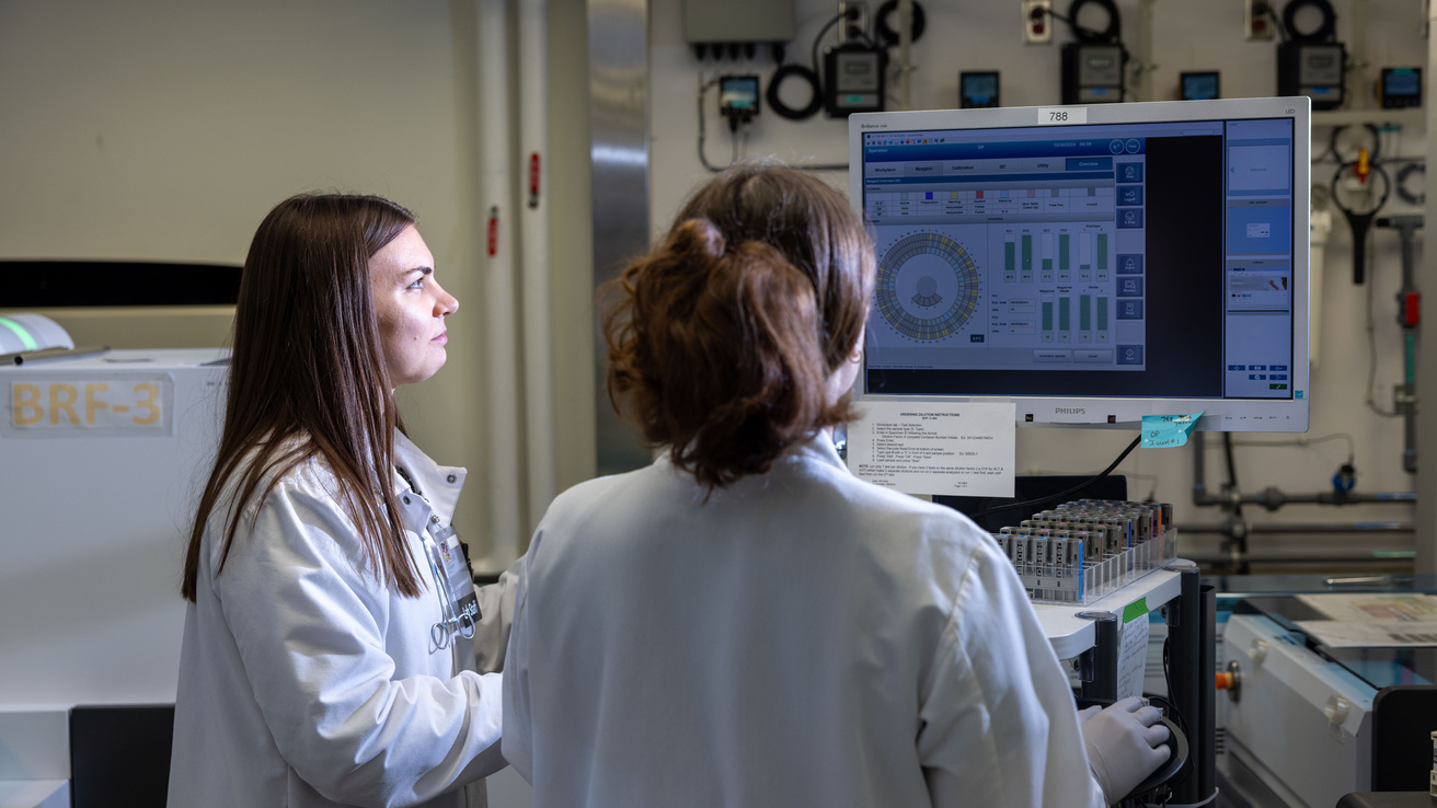 Two people looking at a computer screen in the core labs